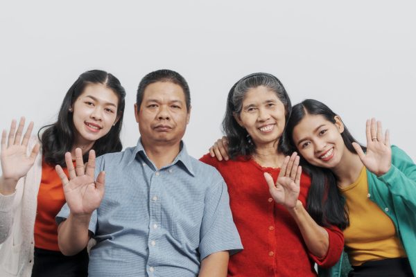 Elderly asian father and mother with old sister and young sister real people sitting on sofa.